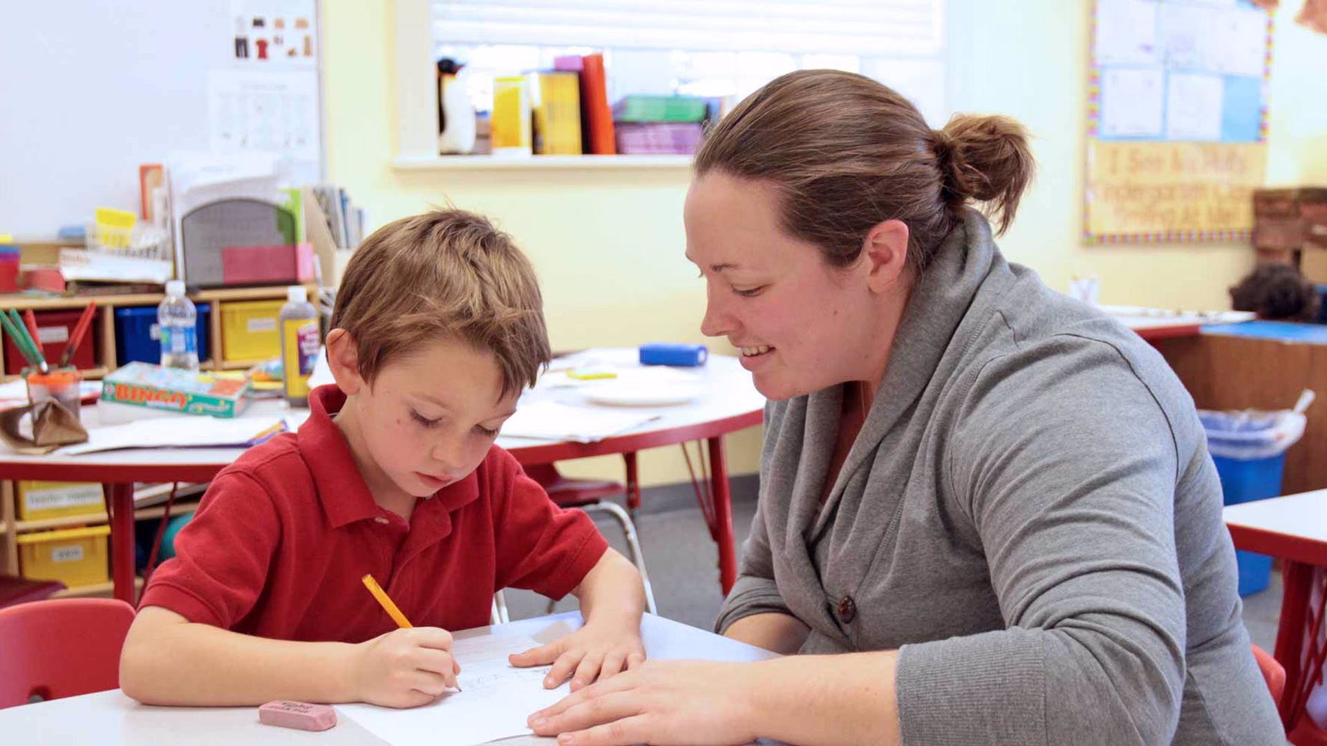 Child learning with teacher in classroom