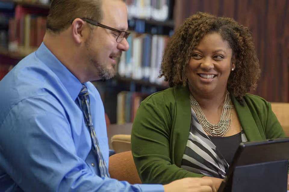 Man and woman talking in library
