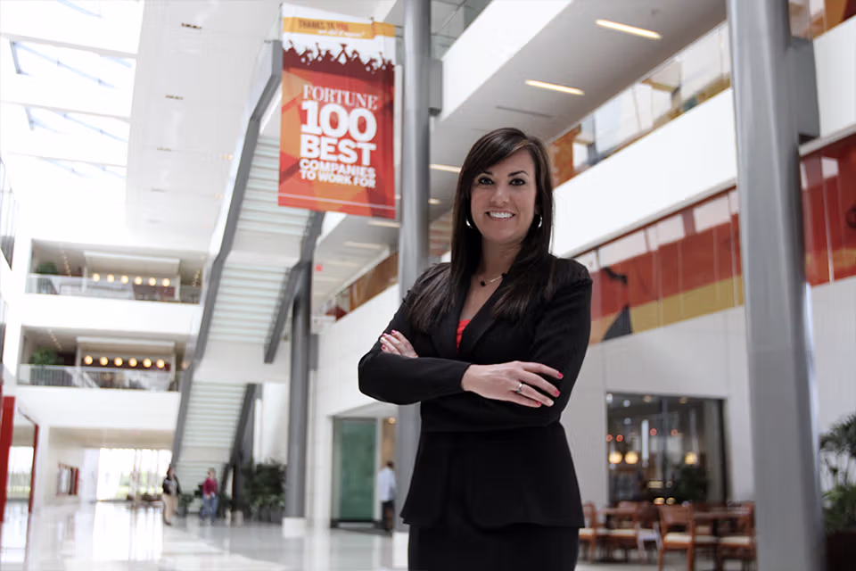 women standing in front of a sign that says "fortune 100 best companies to work for"
