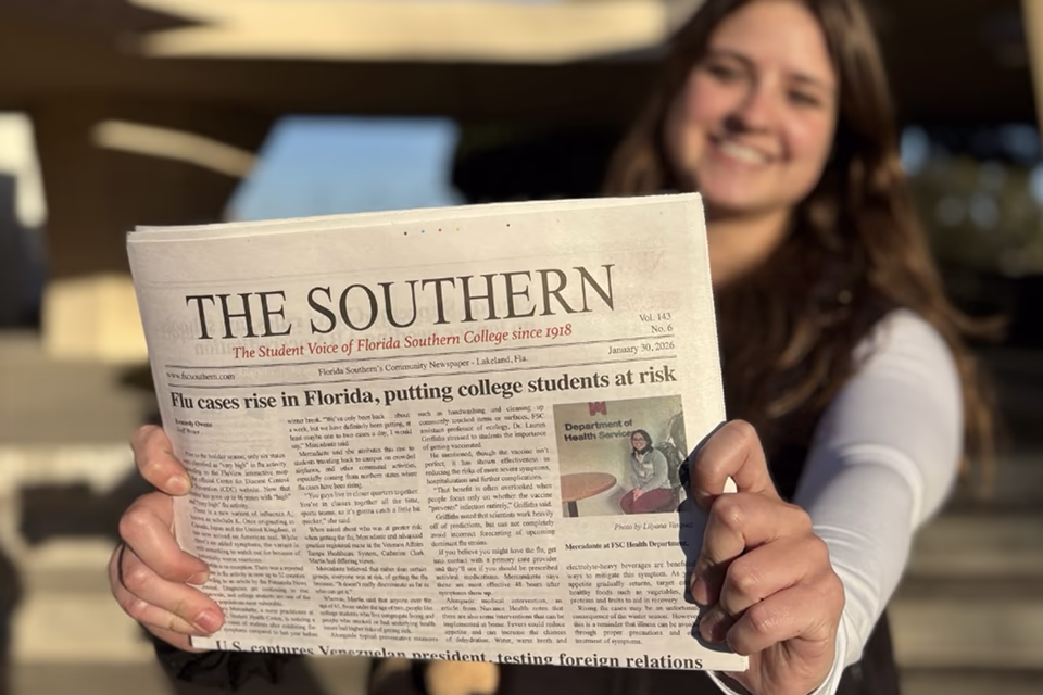 student holding the campus newspaper publication