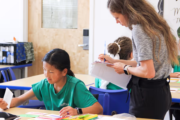 A teacher working with a group of young students