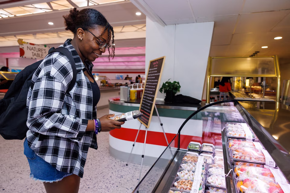 Student picking sushi out of glass case