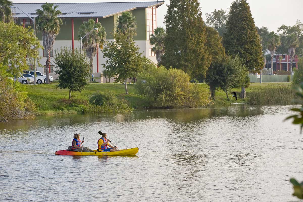 student kayaking on the lake with fsc buildings in the background