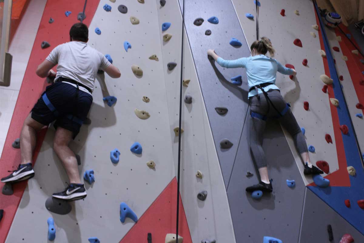 student climbing the rock wall 